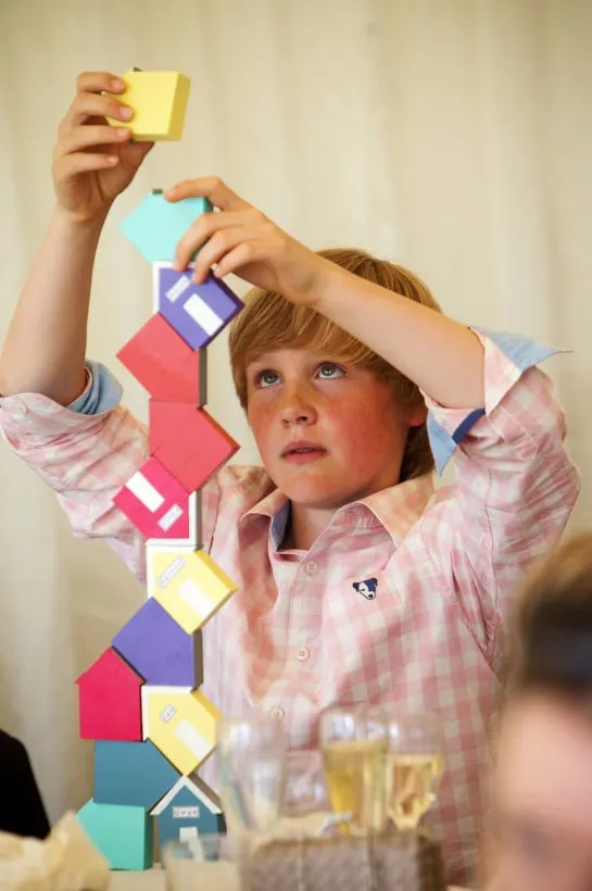 Steady as she goes! A wedding guest uses some table decorations to make his own game.